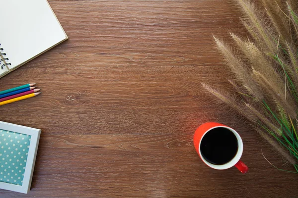 Рабочее место с травой, ноутбуком, кофе, карандашами на столе — стоковое фото