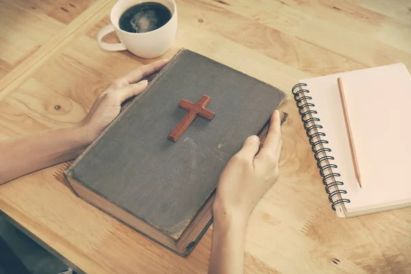 Vintage tone of wooden Christian cross on the Bible during prayer — Stock Photo, Image