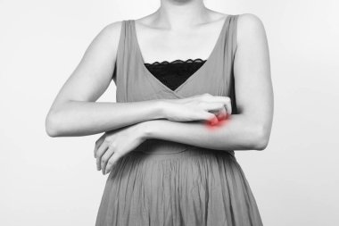 Kolunu kaşıyan bir kadın..