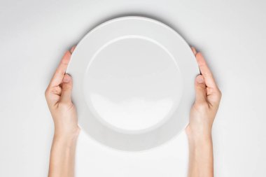 Kadın iki el Beyaz ve üst görünümde izole beyaz bir çanak tutun.