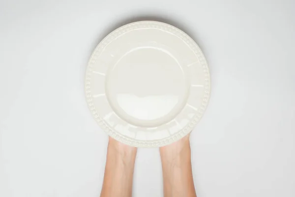 Две руки женщины держат блюдо на белом фоне — стоковое фото