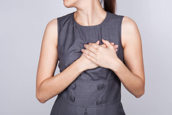 Woman is clutching her chest, acute pain possible heart attack