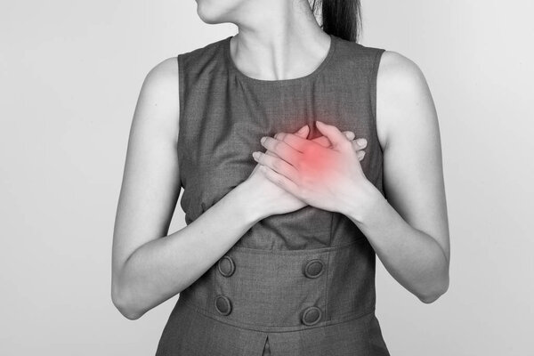 Woman is clutching her chest, acute pain possible heart attack