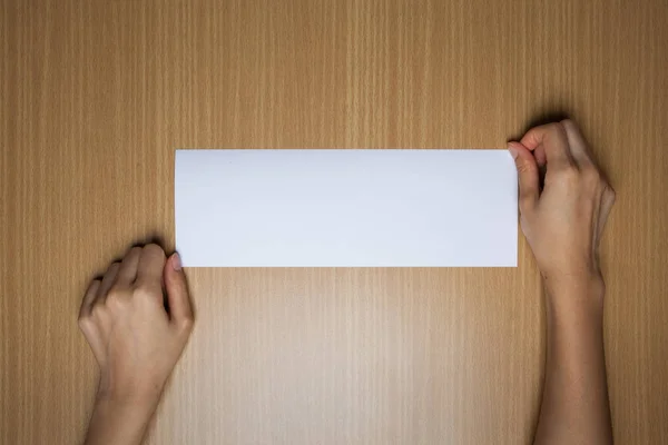 一位女性（女性）手在桌子上拿着一个白色空白（空）标志 — 图库照片
