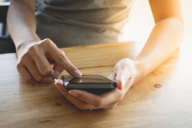 Beyaz gömlekli kız cep telefonuyla kaydediyor