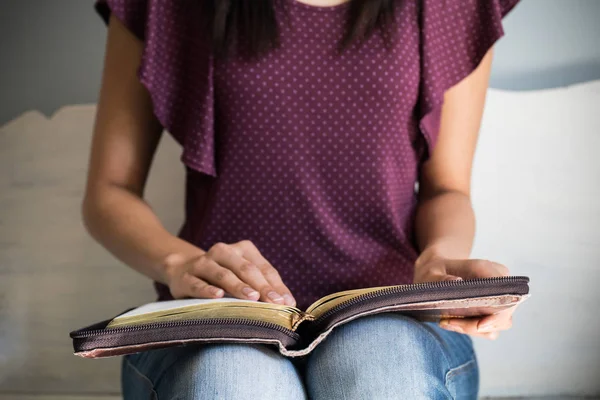 Közelkép egy fiatal nőről, aki egy nagy bibliát olvas, összpontosítson a Bibliára.. — Stock Fotó