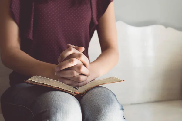 Tom vintage de mulher mãos na bíblia. ela está lendo e orando sobre a Bíblia — Fotografia de Stock