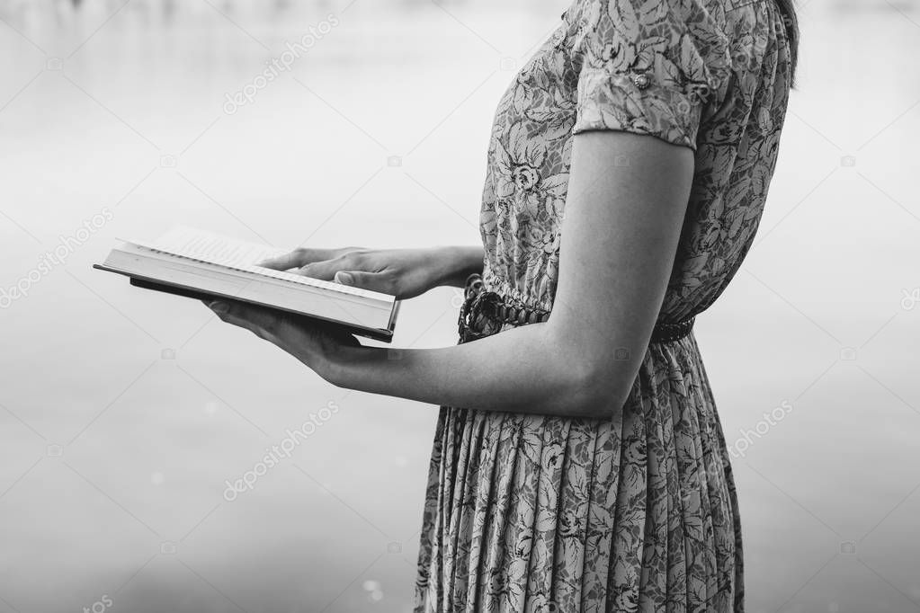 Young woman reading bible in natural park