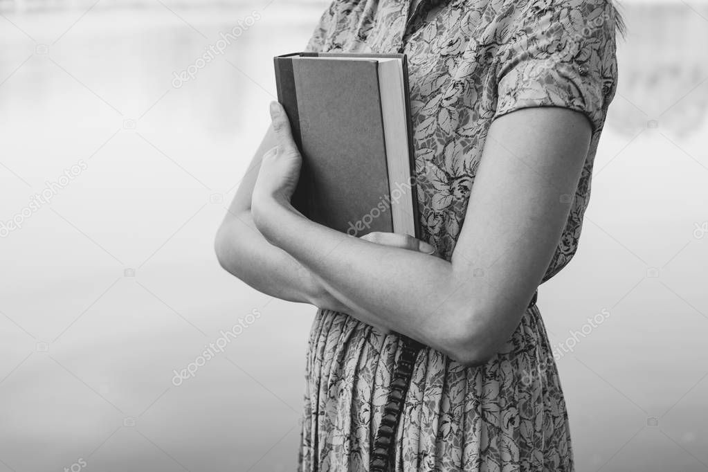 Young woman holding bible in natural park