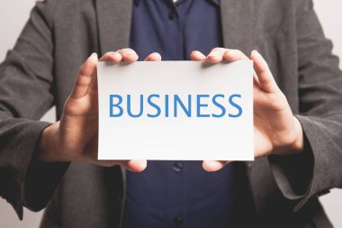 Genç iş kadını kartvizitini tutuyor..