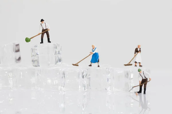 Miniature workers work with ice cube — Stock Photo, Image