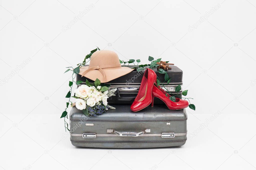 suitcase with red shoes, and hat ready for travel 