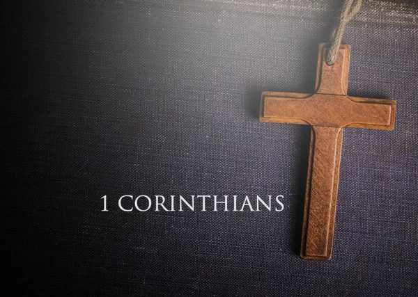 Une croix avec le livre biblique de 1 corinthiens — Photo