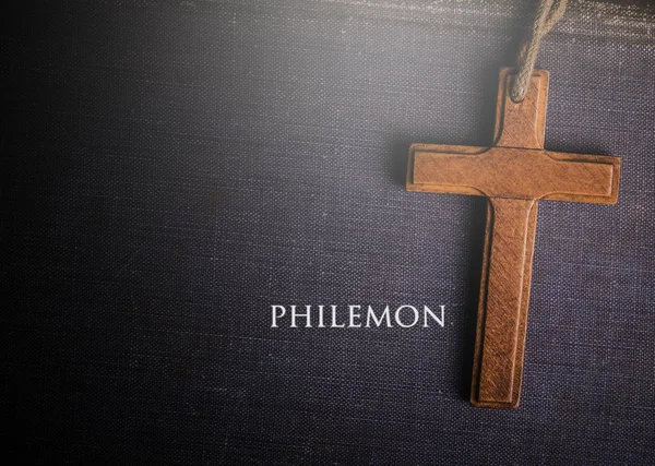 Une croix avec le livre biblique de Philémon — Photo