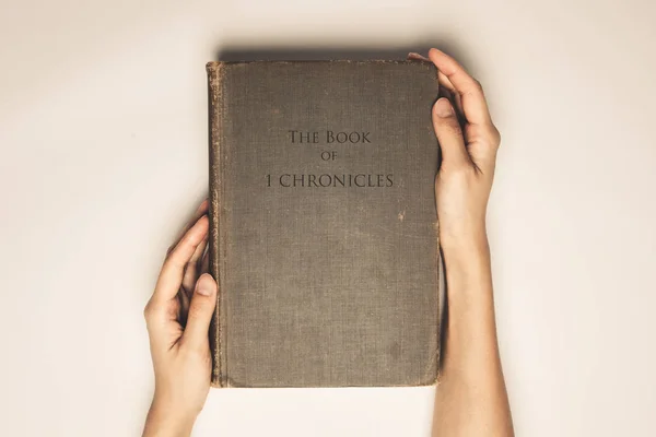 Tom vintage de mãos segurar o livro bíblia de 1 crônicas — Fotografia de Stock