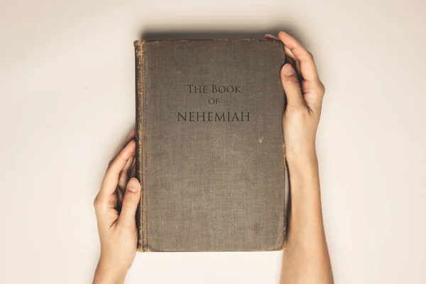 Tom vintage de mãos segurar o livro bíblia de neemias — Fotografia de Stock