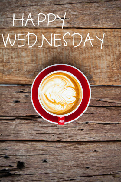 Happy Wednesday word on red cup of coffee on wooden table