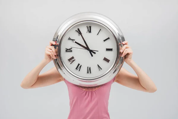 Frau hält Uhr vor weißem Hintergrund — Stockfoto