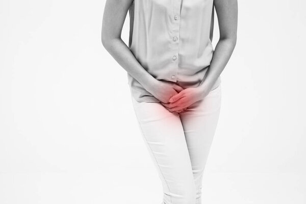 woman with hands holding her crotch isolated in a white background