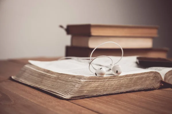 Vintage τόνος της Βίβλου με τα ακουστικά. Ακούγοντας την έννοια της φωνής του Θεού. — Φωτογραφία Αρχείου