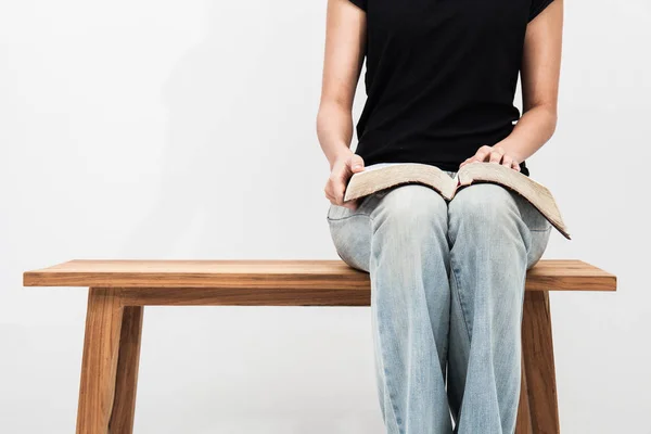 Повсякденна молода жінка тримає відкриту Біблію на її колінах. — стокове фото