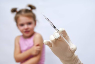 Küçük kız için aşı enjeksiyon yapıyor doktor