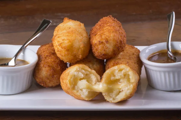 Brazilian snack with melted cheese. Fried cheese croquette with