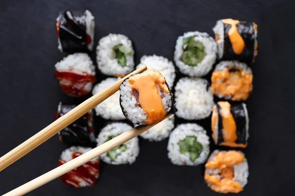 Tasty sushi rolls on a serving board, top view. Japanese food.