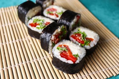 Bambu hasırında lezzetli suşi ruloları. Japon yemeği..