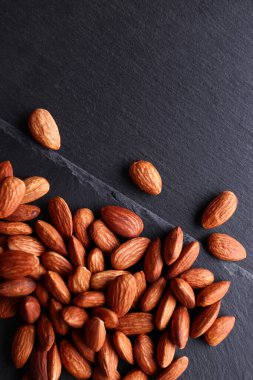 Karanlık bir arka planda badem. Kaçık. Üst görünüm.