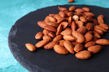 Yuvarlak servis panosunda bir avuç badem. Çatlak..