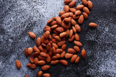 Siyah arkaplandaki birçok bademin renkli fotoğrafı, üst görünüm