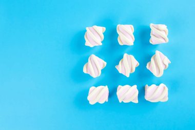 Mavi arka planda şekerlemeler. Düz yatış ya da üst manzara. Metin için boşluk.