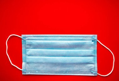Kırmızı arkaplan görünümlü yüz maskesi. Coronavirus koruması ve sağlık hizmetleri. Kopyalama alanı olan koruyucu maske.