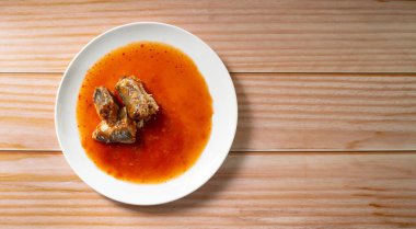 Ahşap arka planda domates soslu konserve balık, sardalya, uskumru, Tayland fast food ve üst manzara.