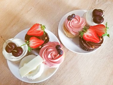 Cupcakes çanak üzerinde ahşap masa ayarla.