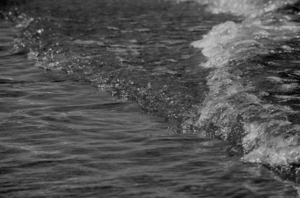 Gece suyu dalgalanması yansımaları. Siyah beyaz arka plan. Koyu ton.