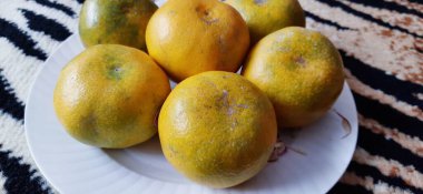 Beyaz bir tabakta altı portakal