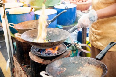 Tay erkek Şef bir noodle domates ve geleneksel şekilde woking havuç ile hazırlama tava üzerinde Tay yastık bir pişirme. 