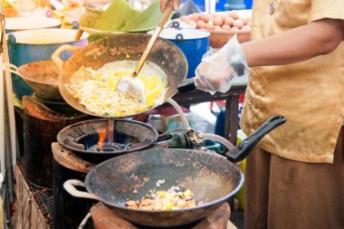 Tay erkek Şef bir noodle domates ve geleneksel şekilde woking havuç ile hazırlama tava üzerinde Tay yastık bir pişirme. 