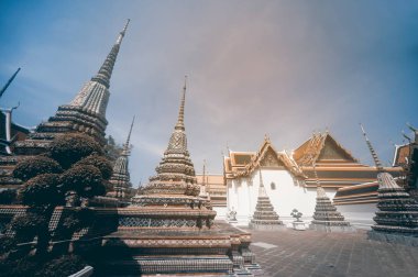 Binalar ve güneşli bir gün boyunca Bangkok Wat Pho Tapınağı'nda pek çok süslü chedi sanatı. Landmark Tayland.