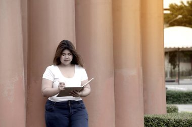 Asyalı güzel gülen yüzü şişman kadın poz ve kutup Park Grup üzerinde düşünme portre. 