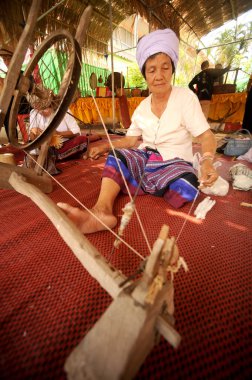 Phayao, Tayland-Mayıs 9,2015: Tanımlanamayan Tai Lue azınlık kadın kıdemli bir iplik geleneksel iplik ile 8 etnik Chiangkum, Tayland Festivali'nde şaşırtıcı bambu yapılmış tekerlek izleri olduğunu.