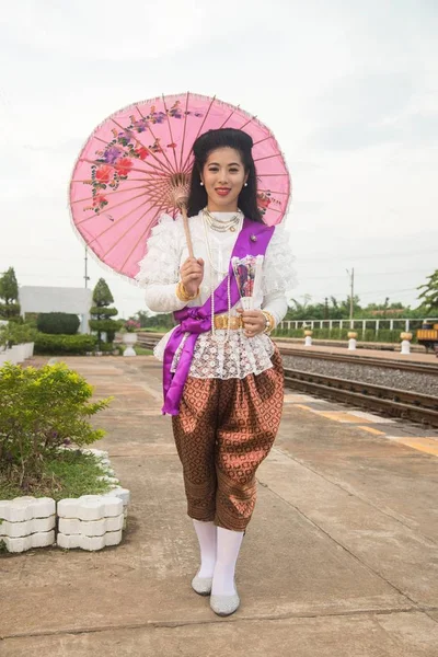 古典的なタイの伝統的なスーツを着るし 駅で紙傘のポーズを保持する中央タイの女性 — ストック写真