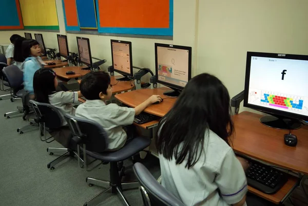 Asiatisches Kind lernt, Computer in der Grundschule im Klassenzimmer zu benutzen. — Stockfoto