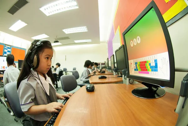 Asiatiska barn lärande att använda datorn på elementära i klass rummet. — Stockfoto