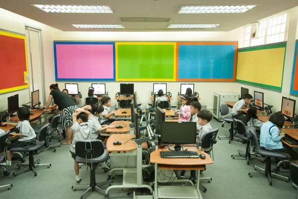 Asiático niño aprendiendo a usar la computadora en la primaria en el aula . — Foto de Stock