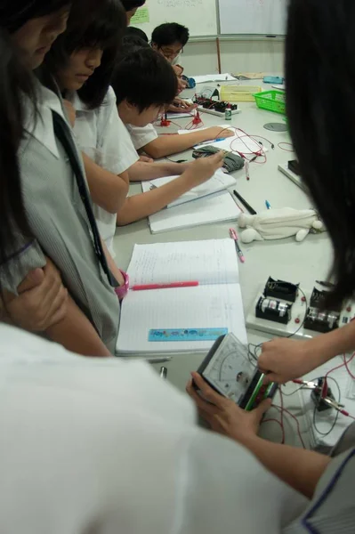 교실에서 전기에 대해 배우고 있는 아시아 초등 학생 그룹. — 스톡 사진