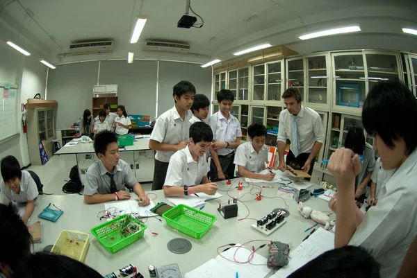 Gruppe asiatischer Grundschüler lernt im Klassenzimmer über Elektrizität. — Stockfoto