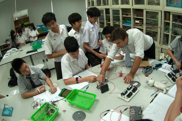 Gruppe asiatischer Grundschüler lernt im Klassenzimmer über Elektrizität. — Stockfoto